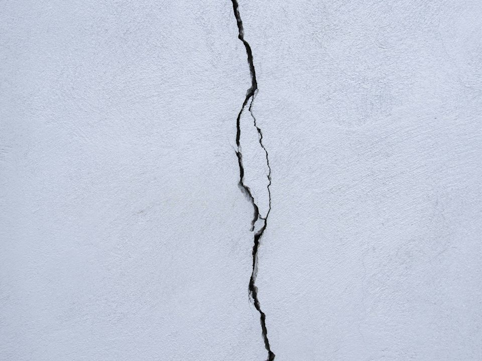 A narrow, dry crack in a painted wall