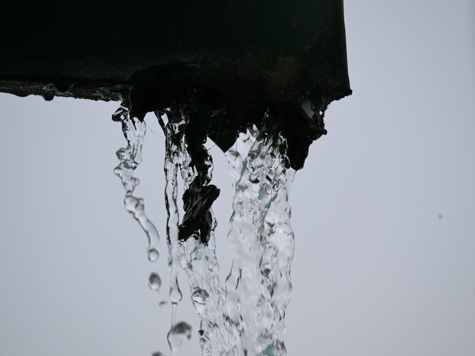 Rainwater pouring off the end of a gutter