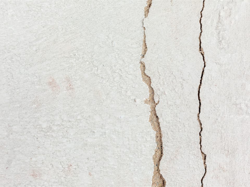 A vertical crack with brown water staining down a wall